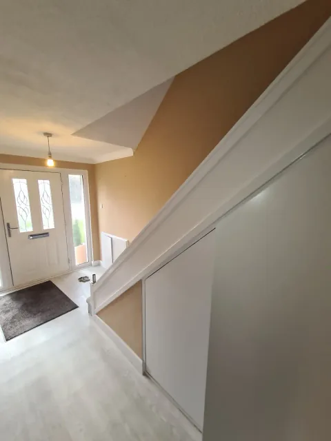 Hallway with a white painted staircase