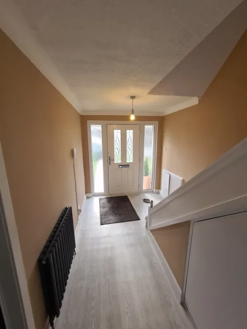 Light hallway with dark doors and radiators