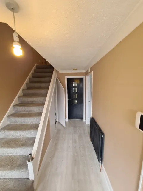 Stairway with neutral walls and white trim